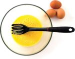 Black 11-inch Grip-EZ Fiskie, a combination fork and whisk utensil, shown in a kitchen setting.