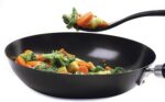 Black 11-inch Grip-EZ Fiskie, a combination fork and whisk utensil, shown in a kitchen setting.