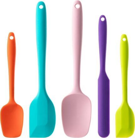A set of five multicolor silicone spatulas with stainless steel cores, arranged for a kitchen product display.